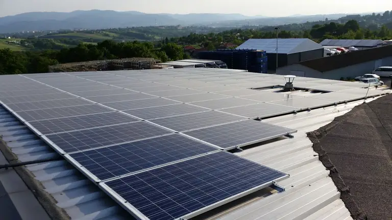 Instalacja fotowoltaiczna z bliska na dachu w tle widać góry