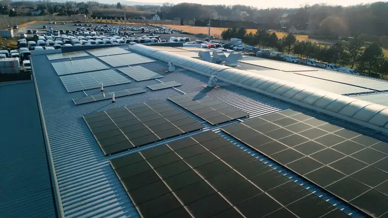 Panele fotowoltaiczne zamontowane na dachu płaskim na firmie