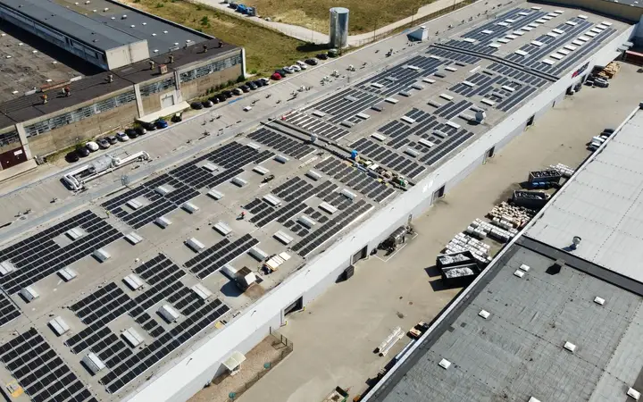 Duża instalacja fotowoltaiczna zamontowana na dachu hal produkcyjnych